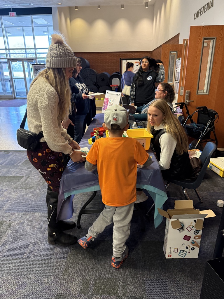 Teachers at a activity table in the high school lobby.
