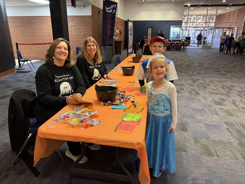 Teachers at a activity table in the high school lobby.