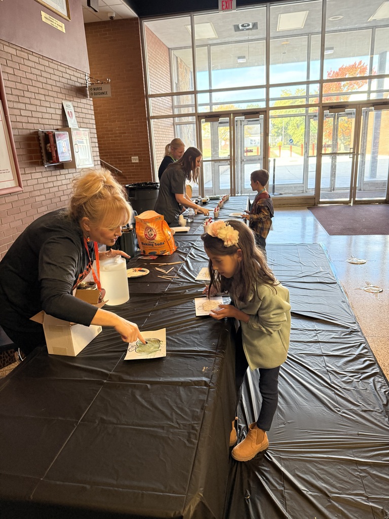 Teachers at a activity table in the high school lobby.