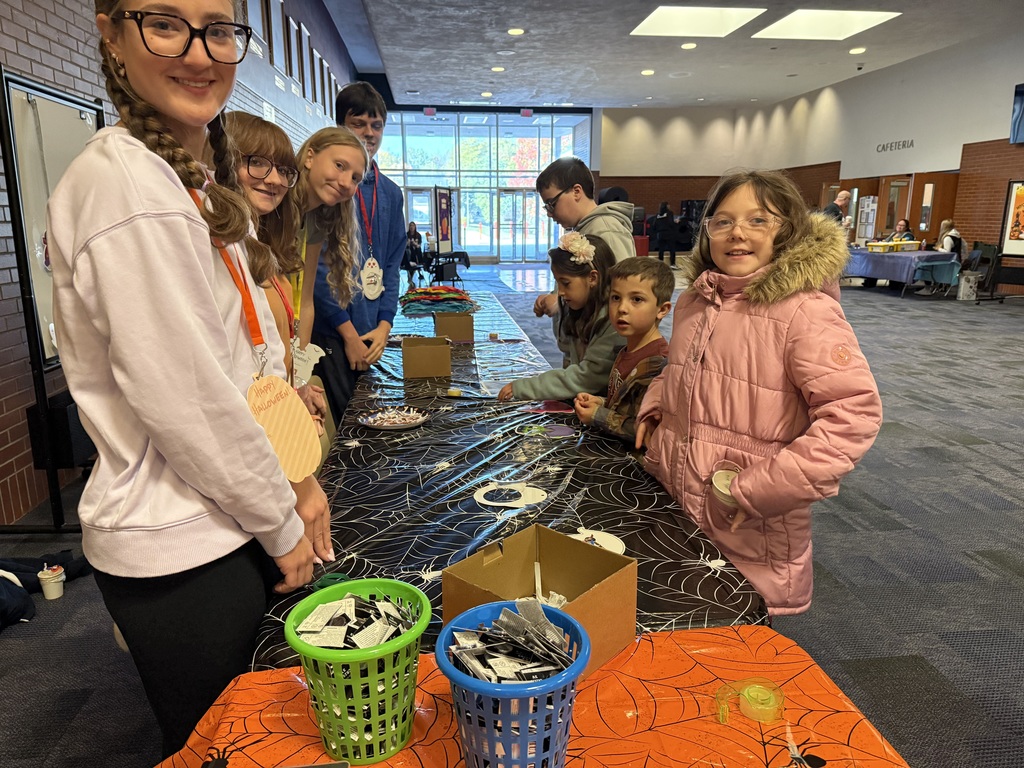 Teachers at a activity table in the high school lobby.