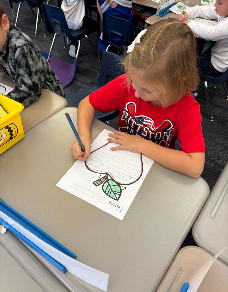 A girl writing about apples.