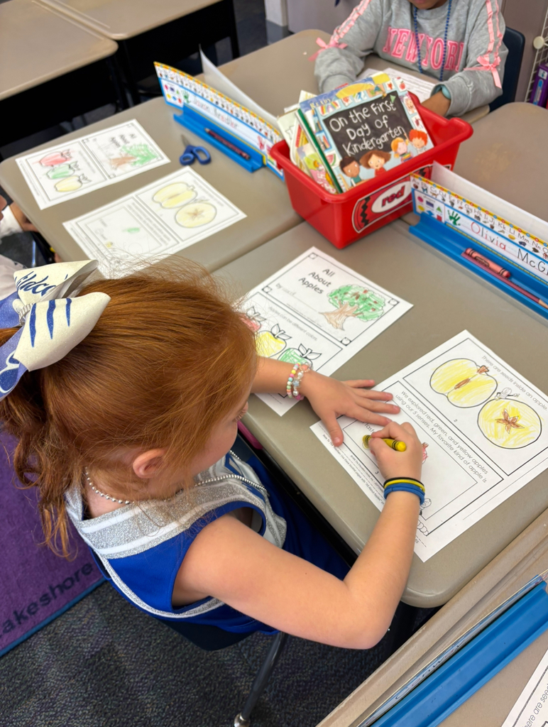 A girl coloring an apple book.