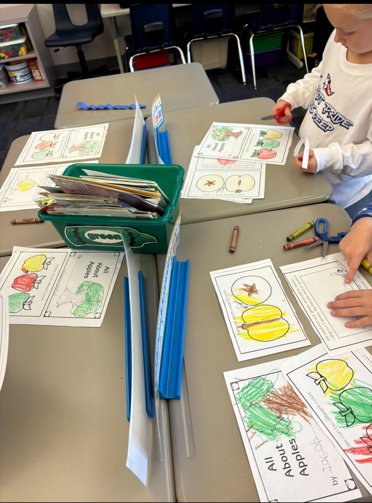 A student coloring an apple book.