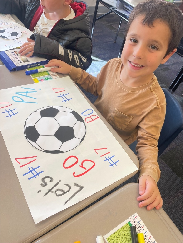 Students making red, white and blue patriot soccer signs.