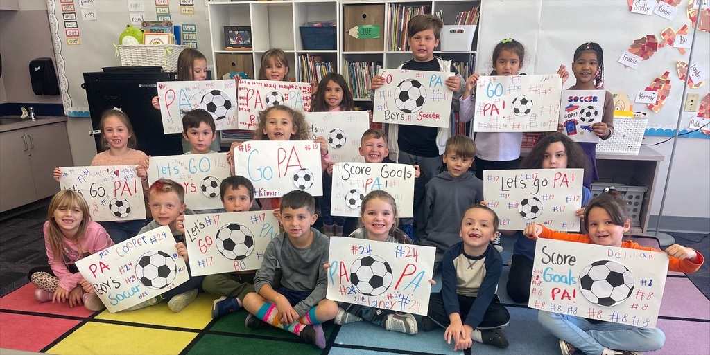Students making red, white and blue patriot soccer signs.