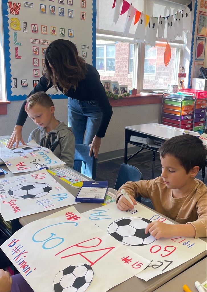 Students making red, white and blue patriot soccer signs.