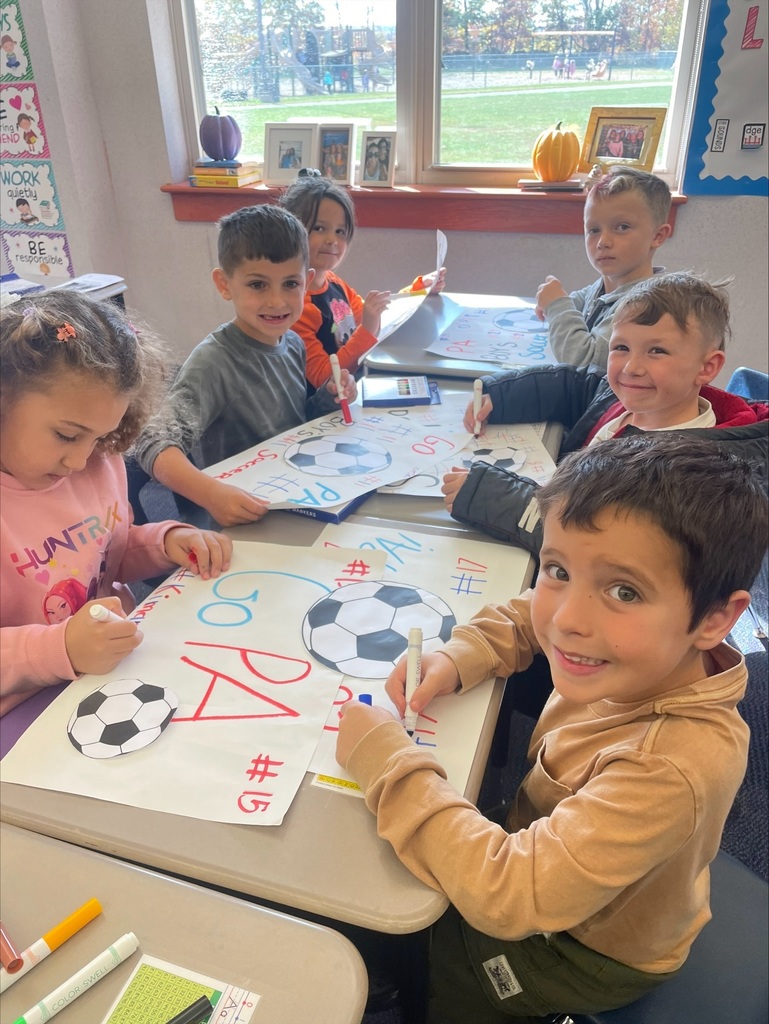 Students making red, white and blue patriot soccer signs.