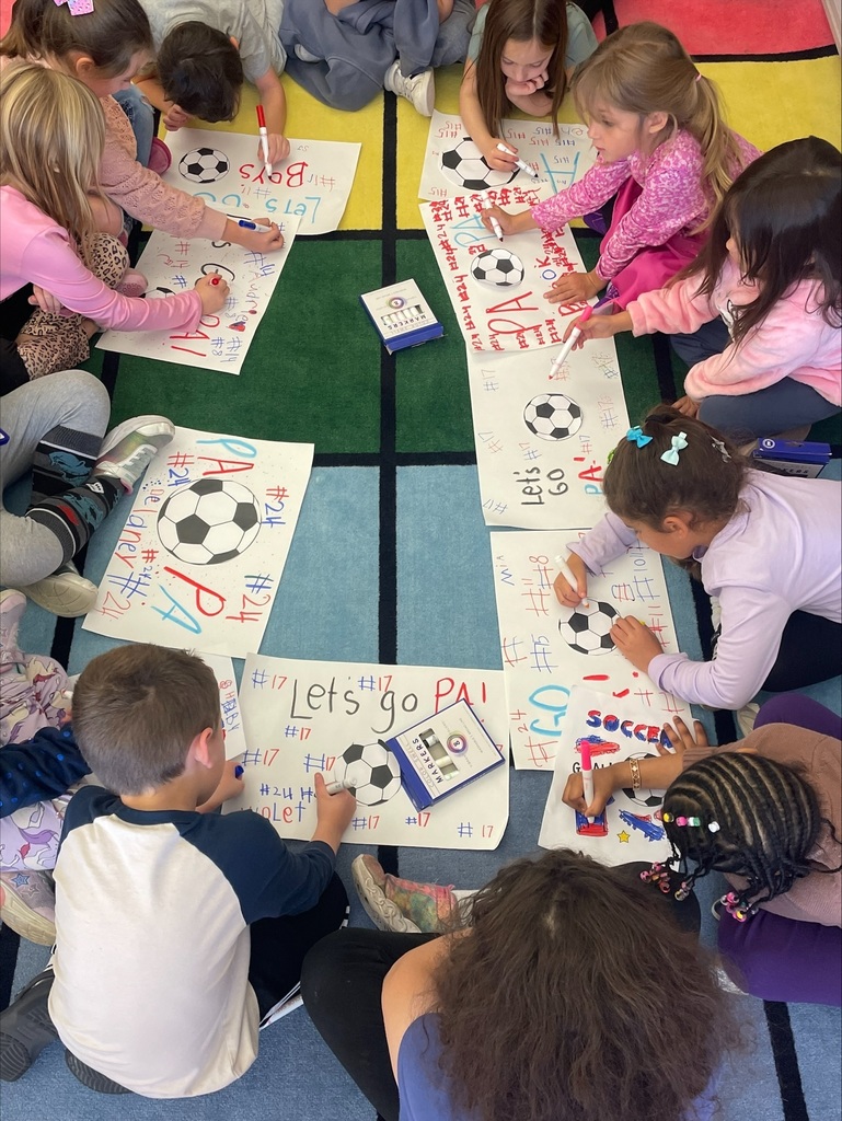 Students making red, white and blue patriot soccer signs.