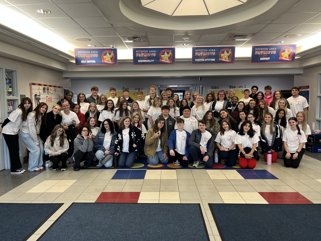 A group of high school students in a school lobby.