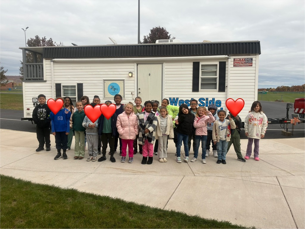 A group of students in-front of a smoke house.