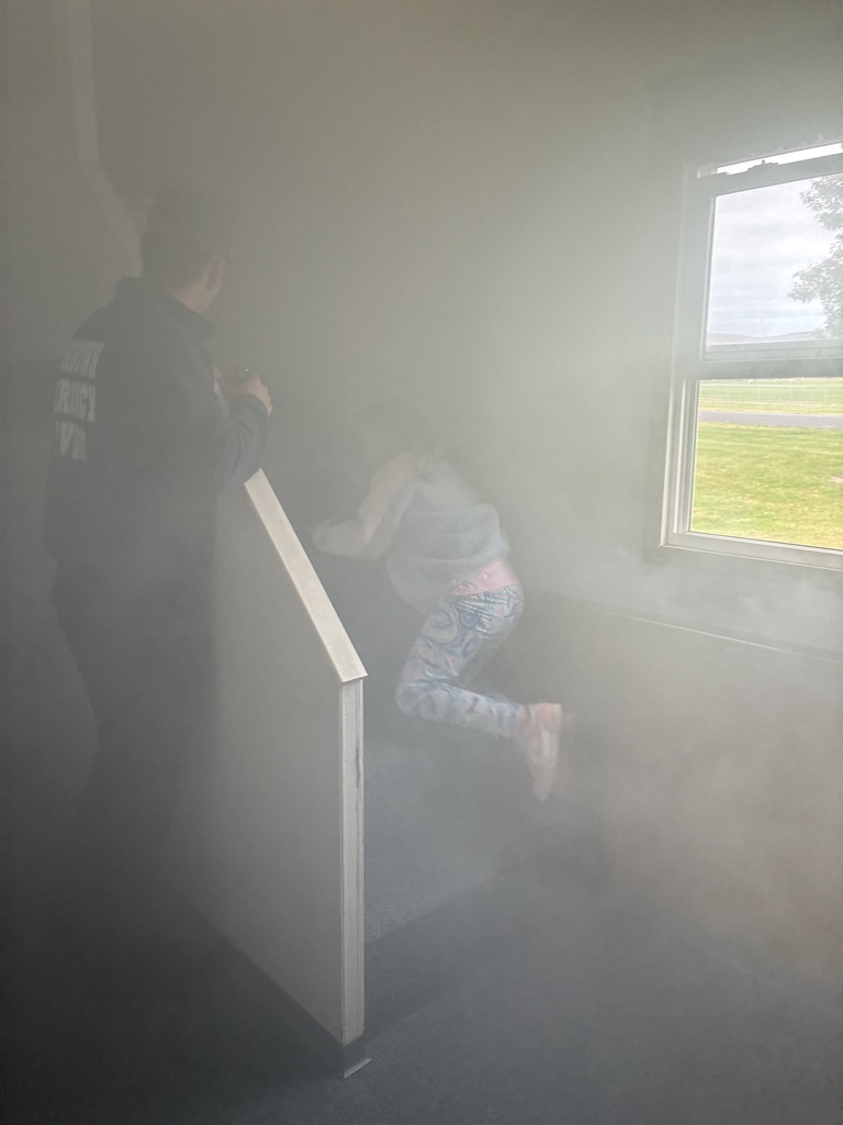 Students in a smoke house filled with smoke.