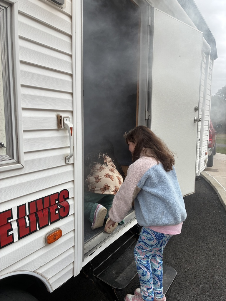 Students in a smoke house filled with smoke.