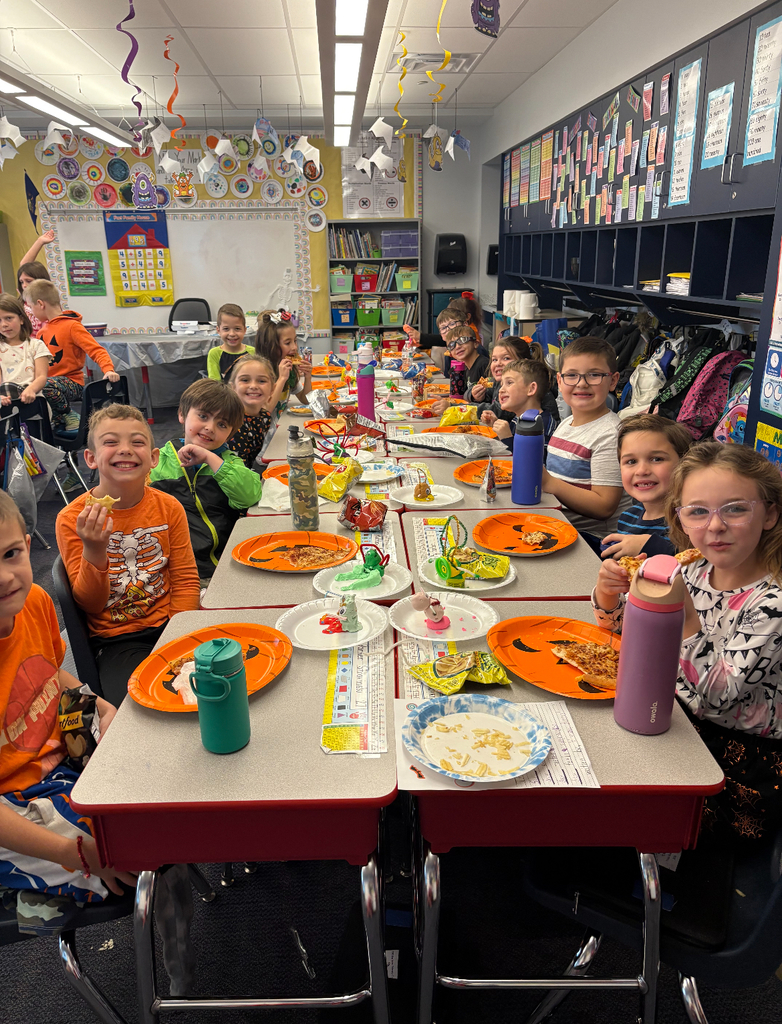Students at a halloween pizza party in their classroom.