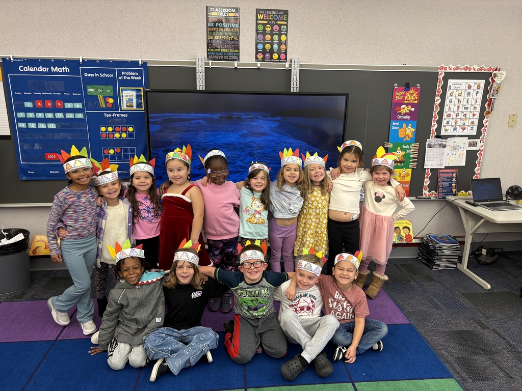 A group of students wearing feathered headbands made from paper
