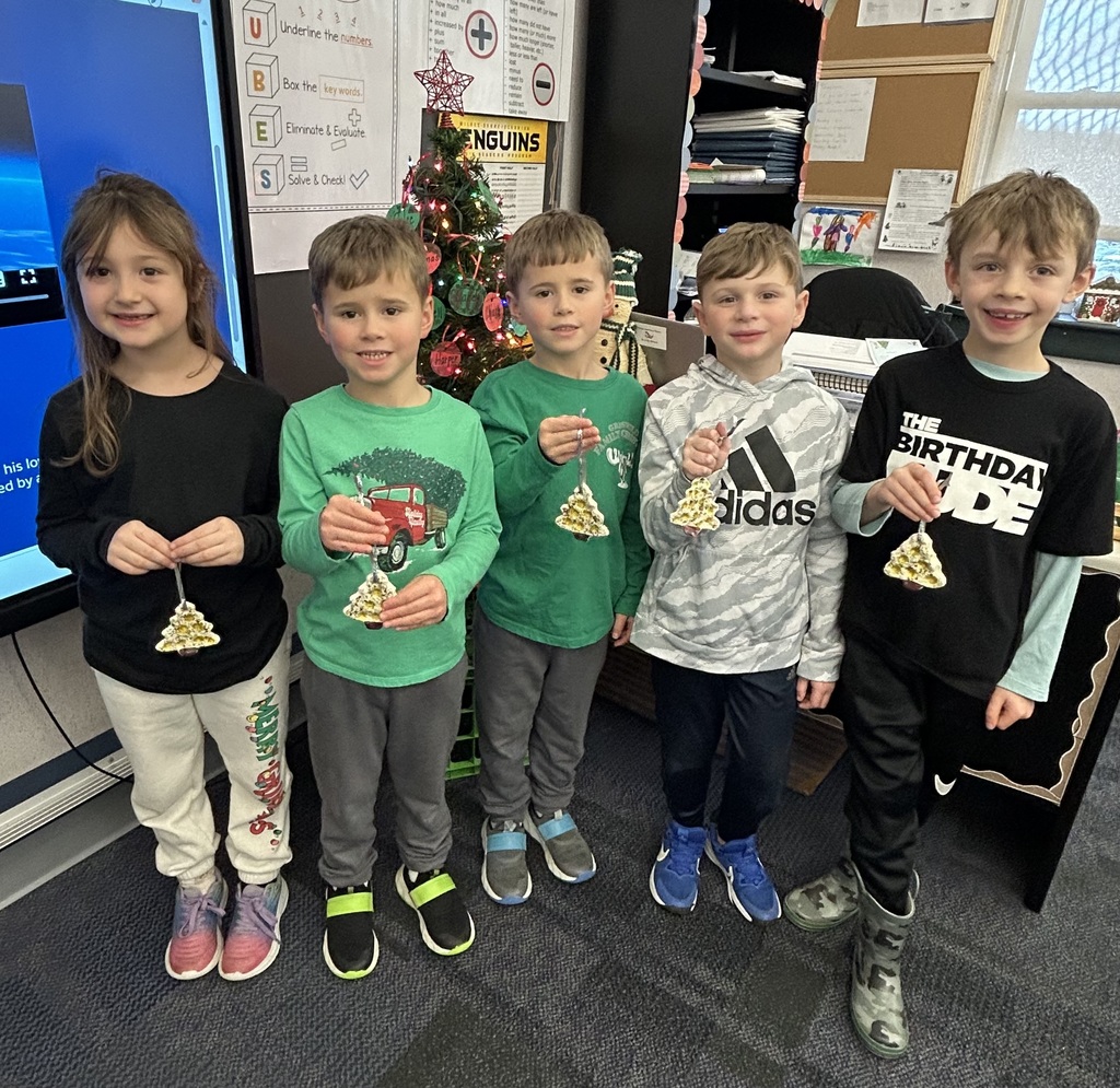 Students holding homemade ornaments. 