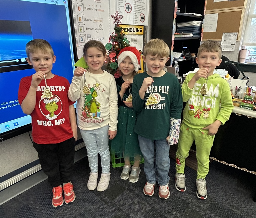 Students holding homemade ornaments. 