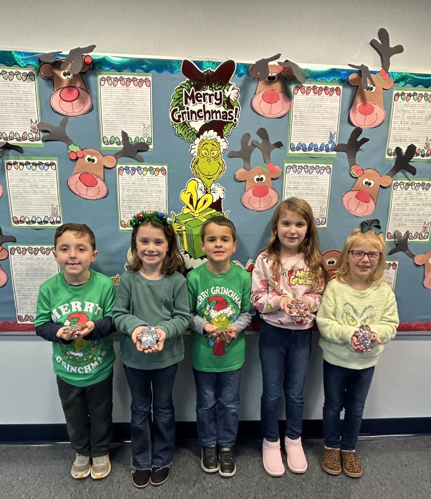 Students holding homemade ornaments. 