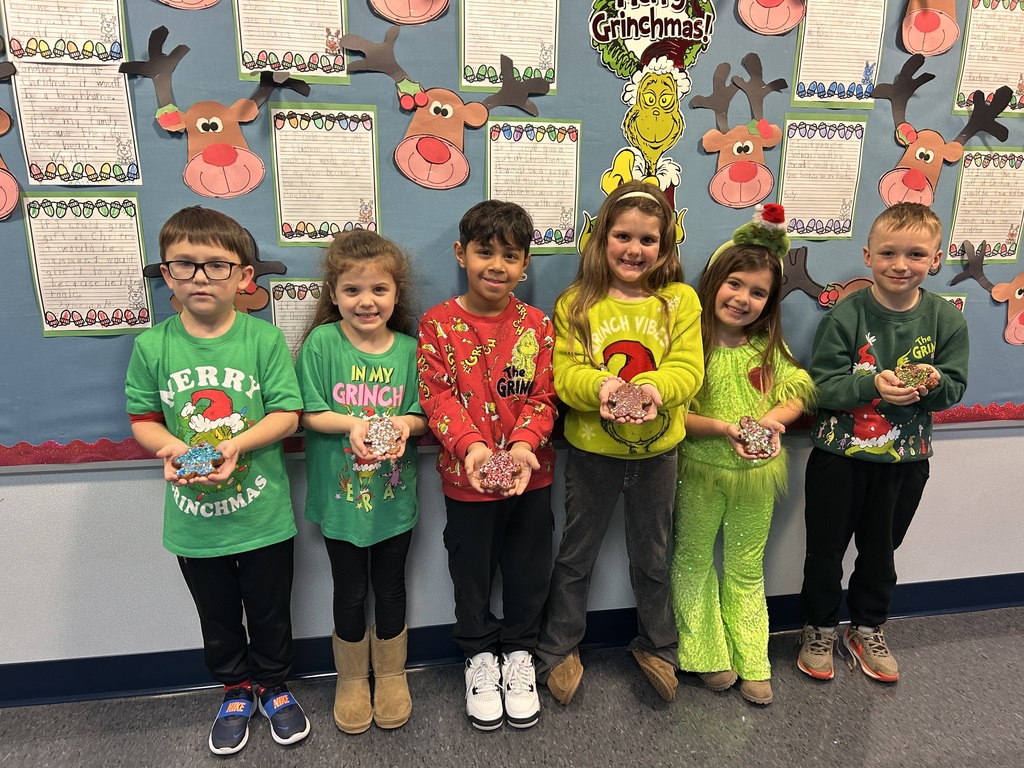Students holding homemade ornaments. 