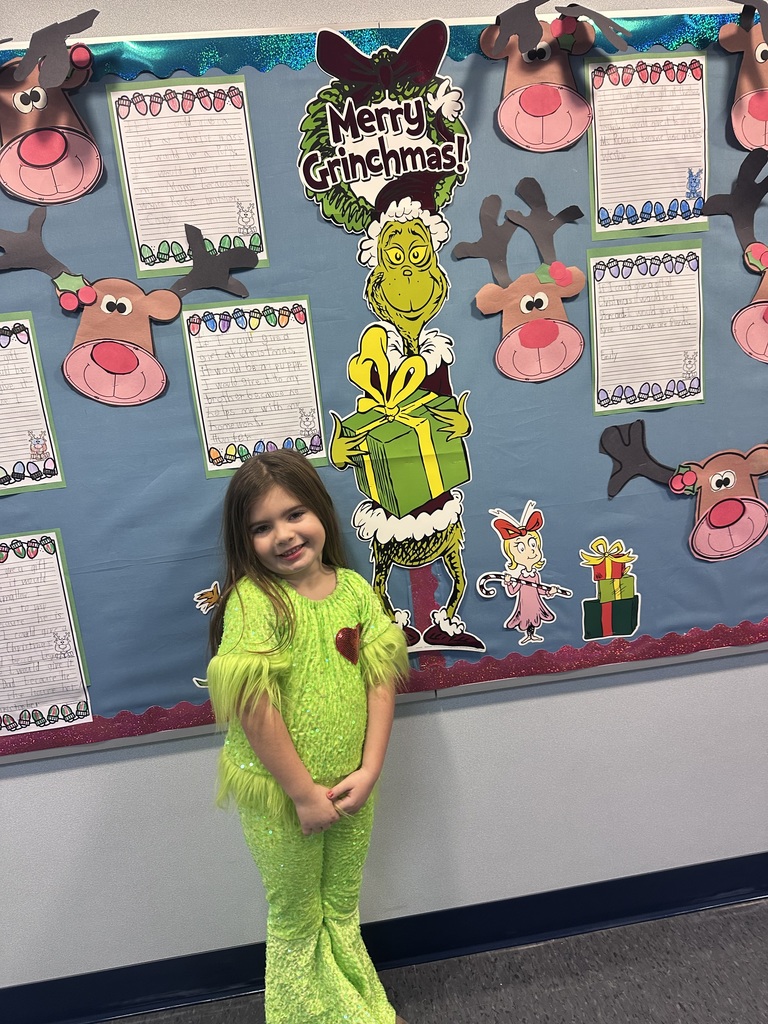 A girl in grinch clothes. 