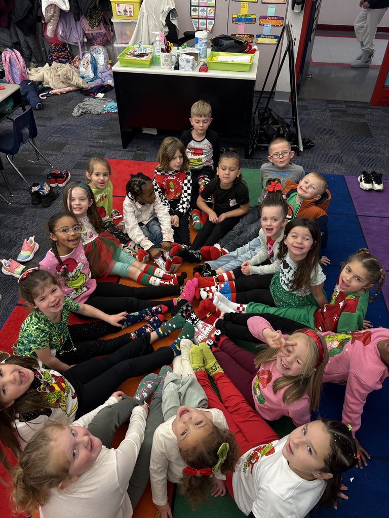 Students in a circle showing off christmas socks. 