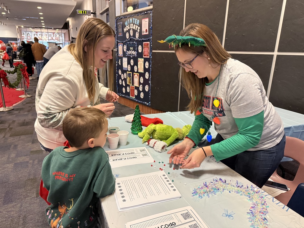 A teacher working with a student and mom. 