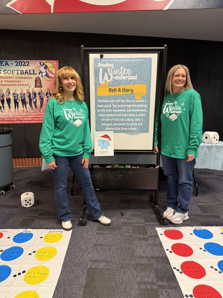 Two teachers smiling in front of a sign for reading wonderland. 