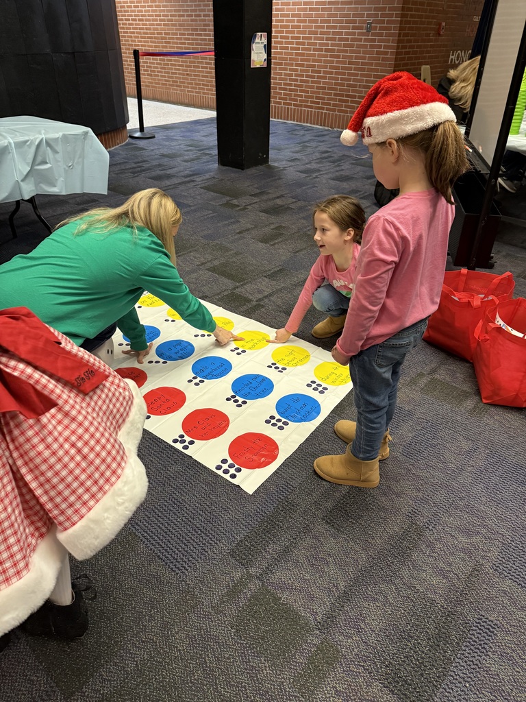 A teacher over a twister board. 