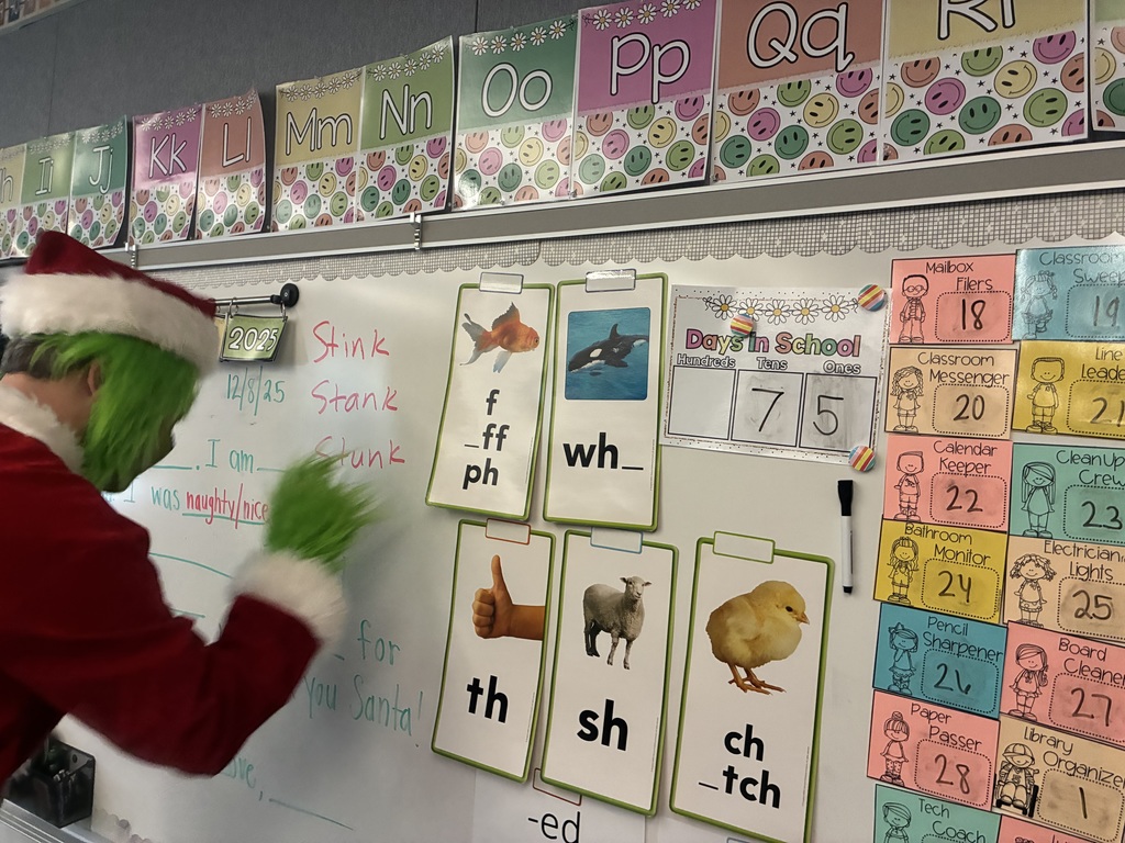 A man in a grinch costume in a school. 