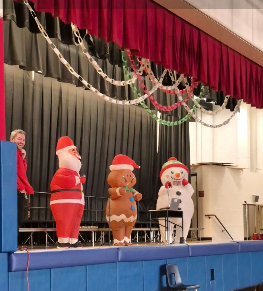 People on a stage in inflatable holiday costumes 