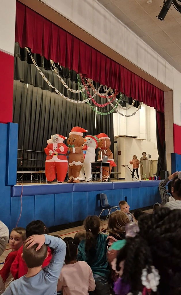 People on a stage in inflatable holiday costumes 