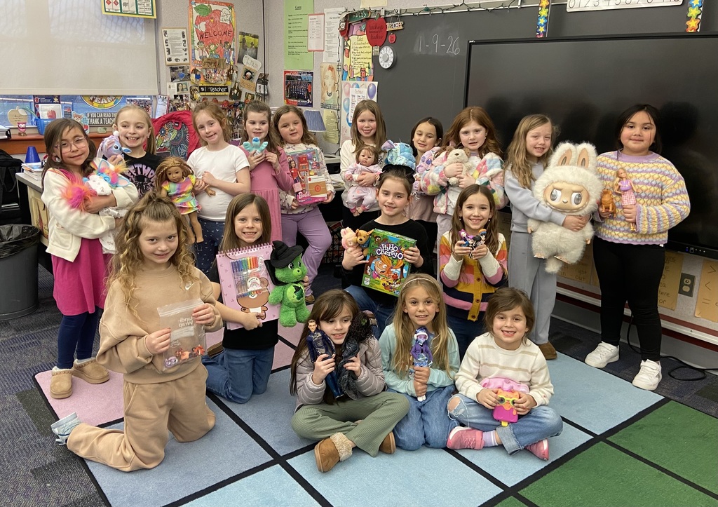 Students holding show and tell items in agroup