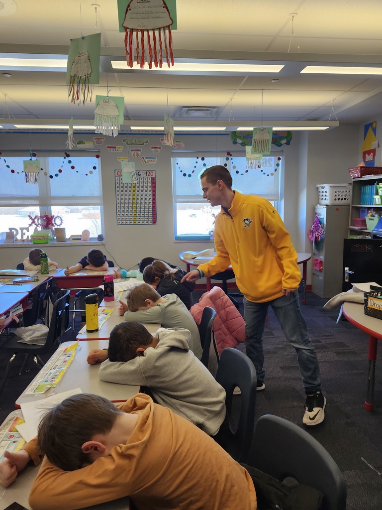 Students in a classroom playing heads up 7 up.