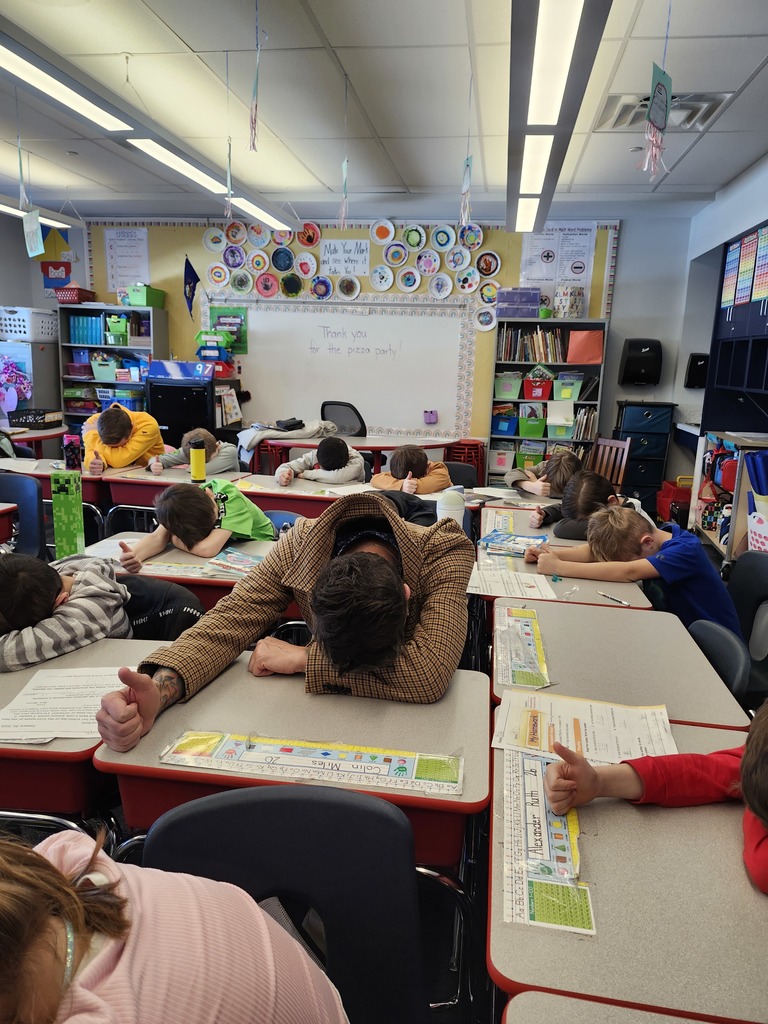 Students in a classroom playing heads up 7 up.