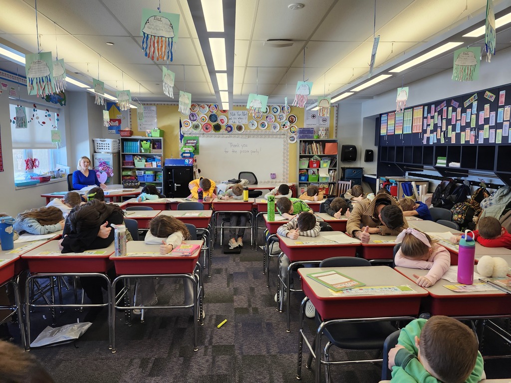Students in a classroom playing heads up 7 up.