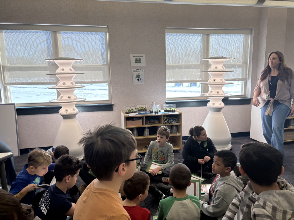 A teacher presenting about hydroponic farm stands.