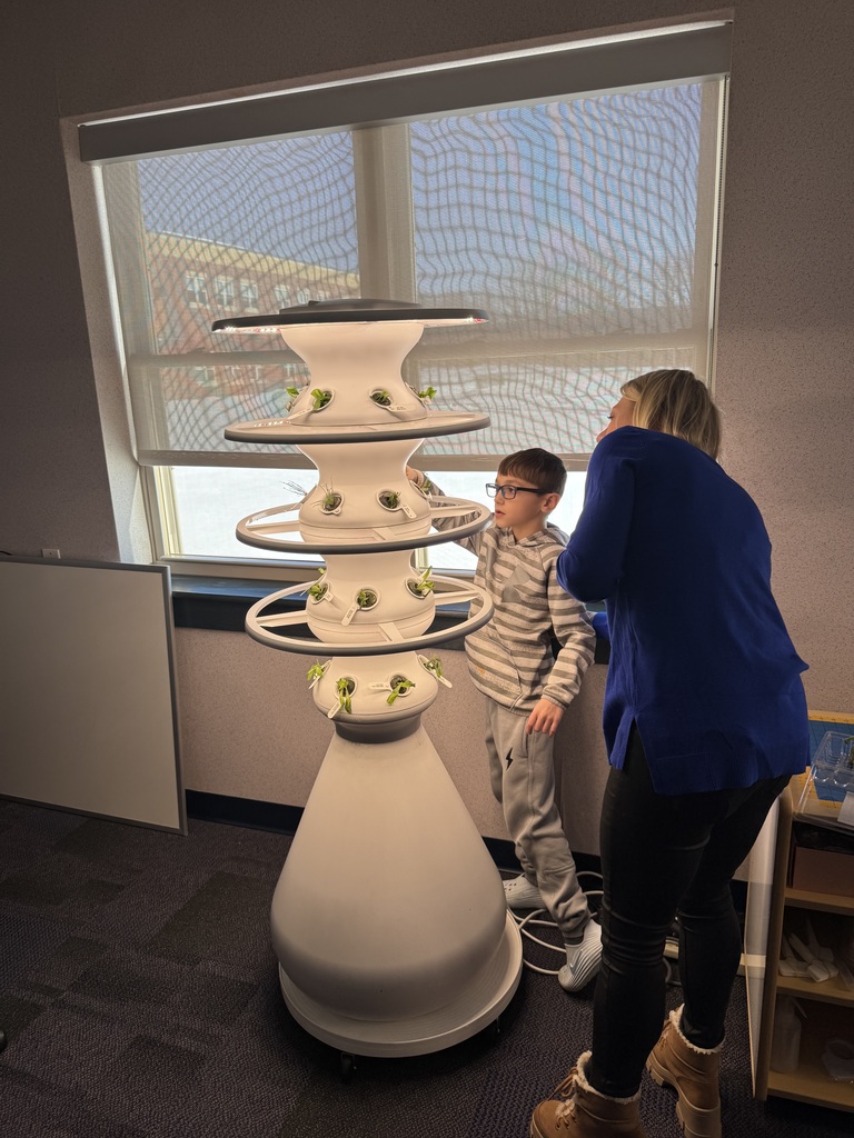 A teacher presenting about hydroponic farm stands.