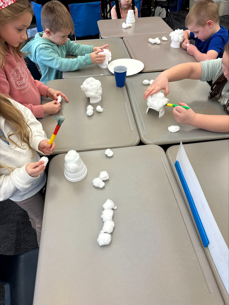 Students with cotton balls making an igloo craft.