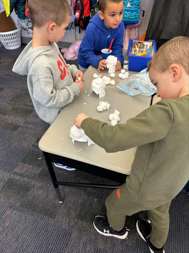 Students with cotton balls making an igloo craft.