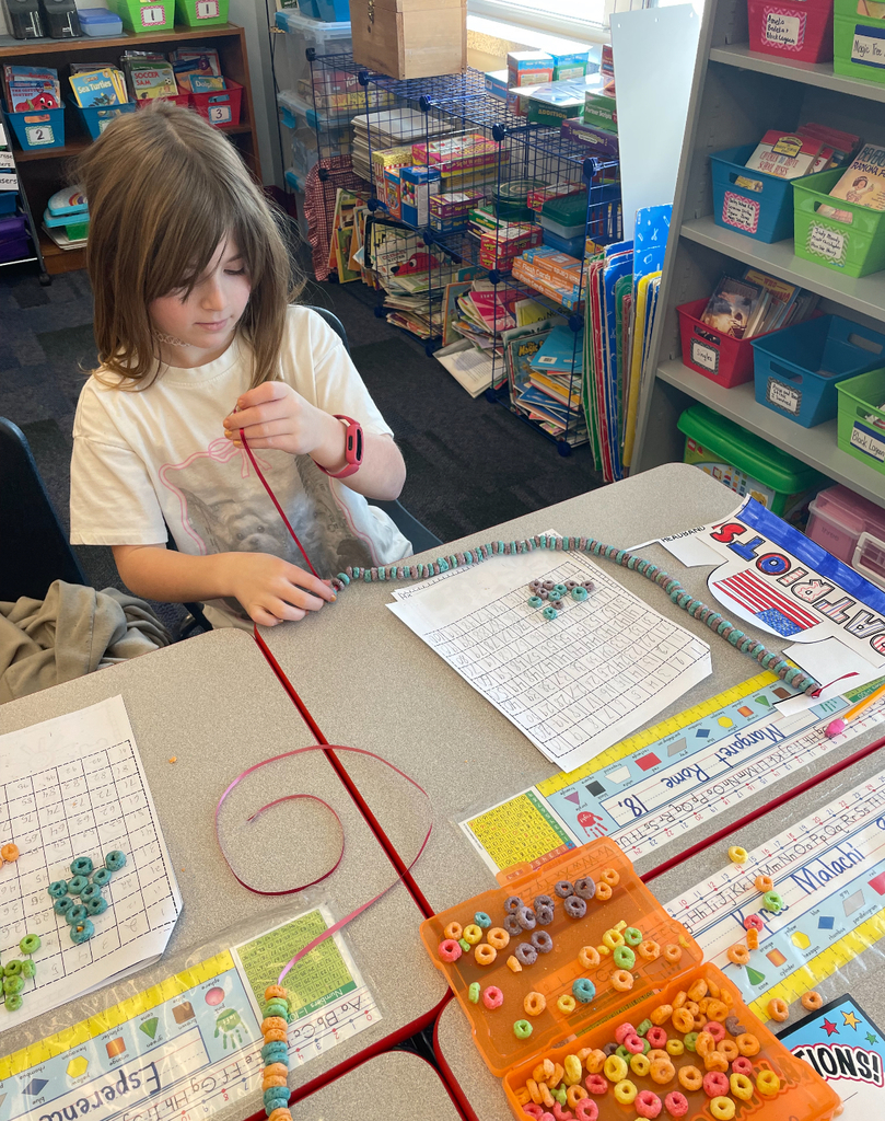 Students making 100 fruit loop necklaces.