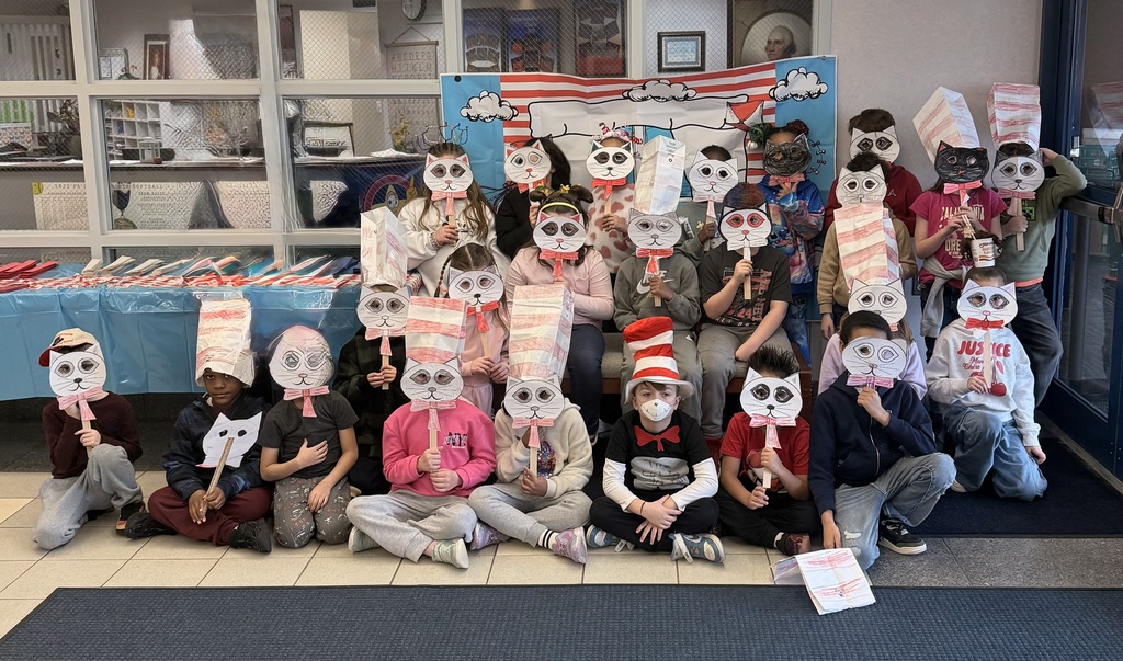 A group of students posing with silly hats and paper cat masks