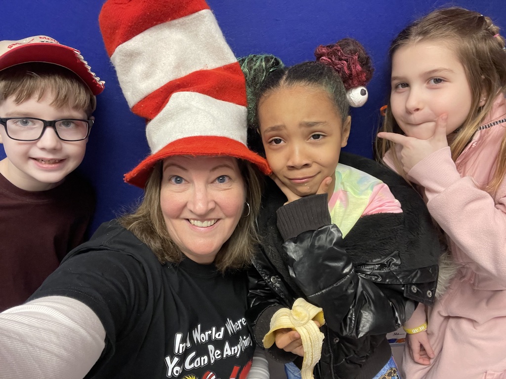 A teacher and a group of students posing with silly hats