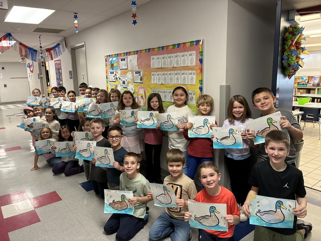 Kids holding duck art smiling at the camera