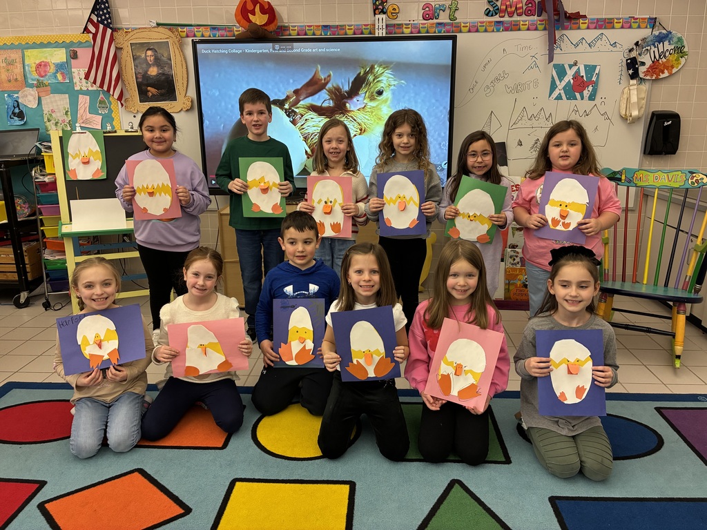 Kids holding duck art smiling at the camera