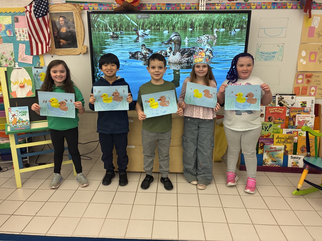 Kids holding duck art smiling at the camera
