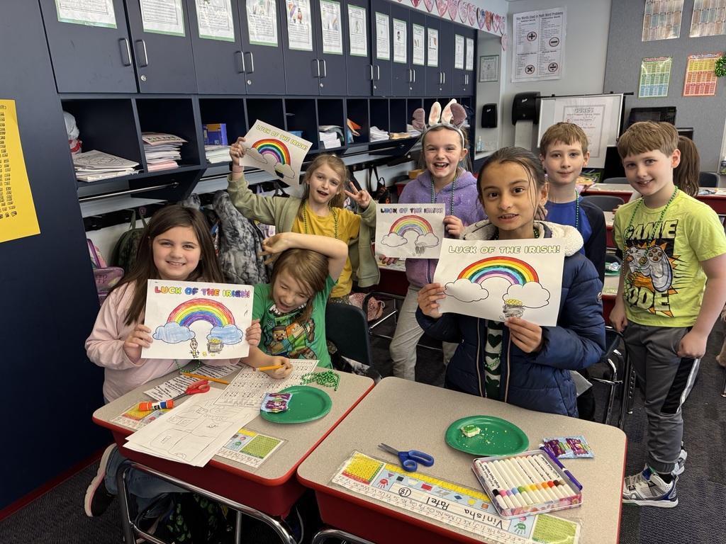 Students holding up rainbow coloring sheets