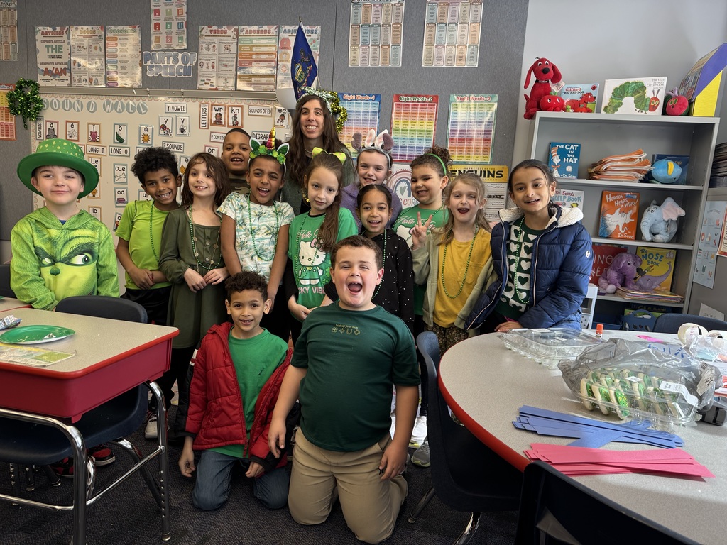 A group of students in a classroom dressed in green