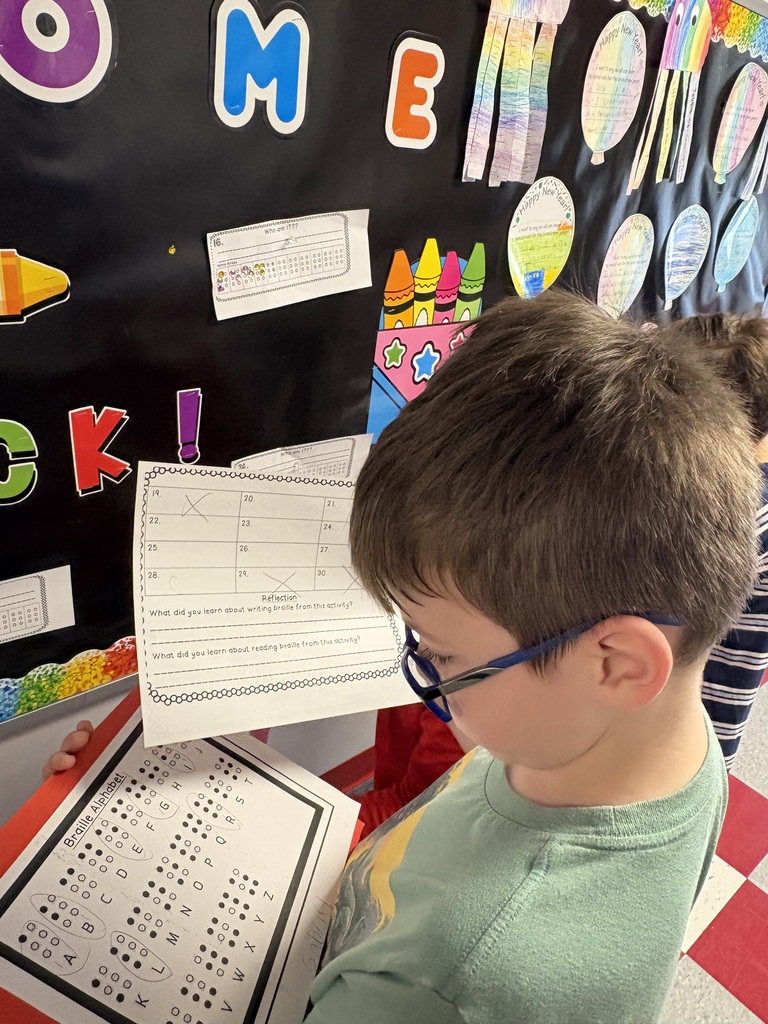 Students exploring braille in a school hallway