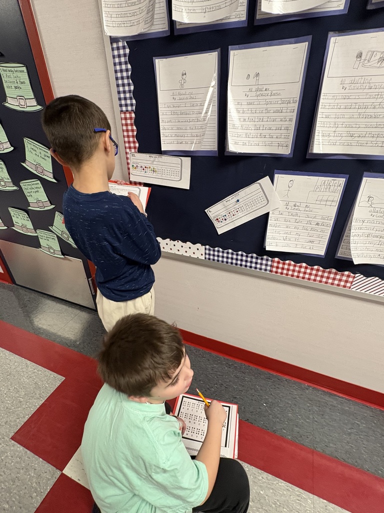 Students exploring braille in a school hallway