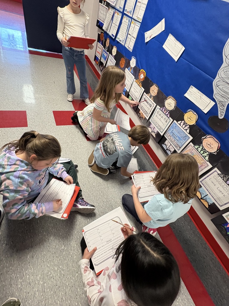 Students exploring braille in a school hallway