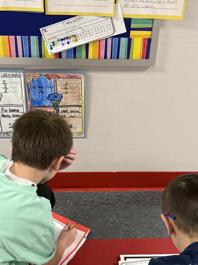 Students exploring braille in a school hallway